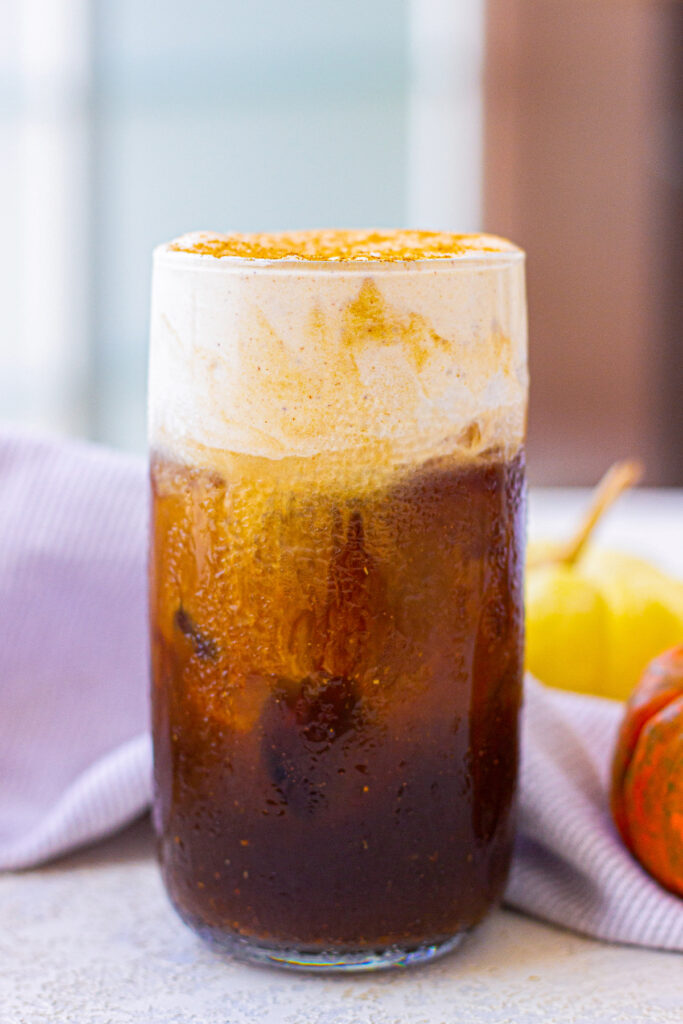 A clear glass with Starbucks Pumpkin Cream Cold Brew coffee. 