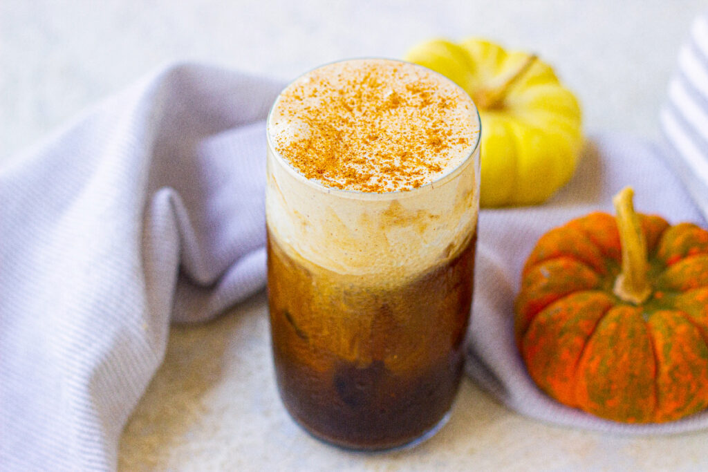 Iced coffee drink with pumpkin flavors in a clear tall glass. 