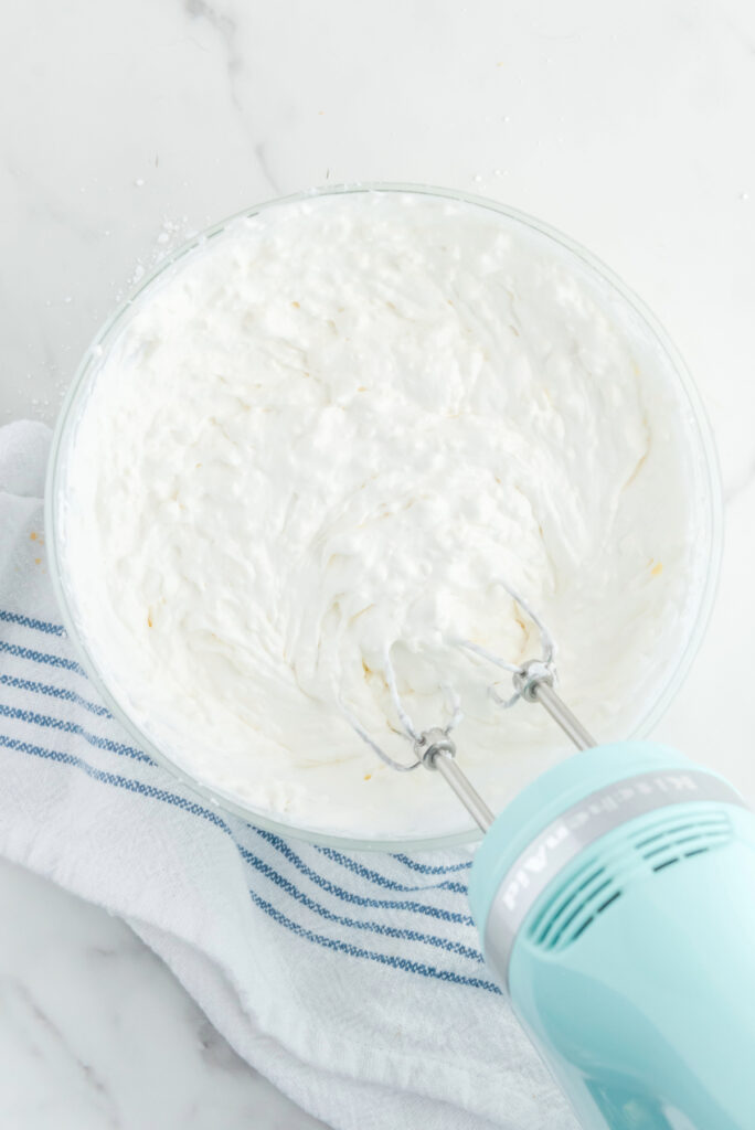 Whipped cream mix in a large mixing bowl. 