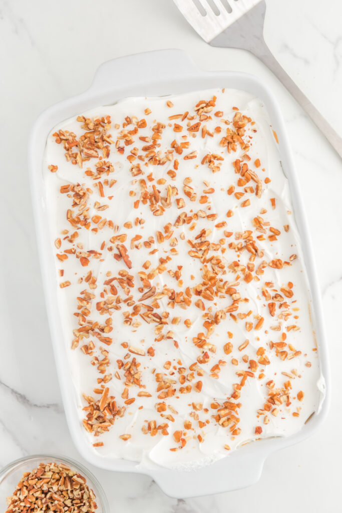 Top view of layered cake recipe topped with pecans.