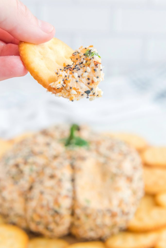 A scoop of cream cheese on a cracker ready to eat. 