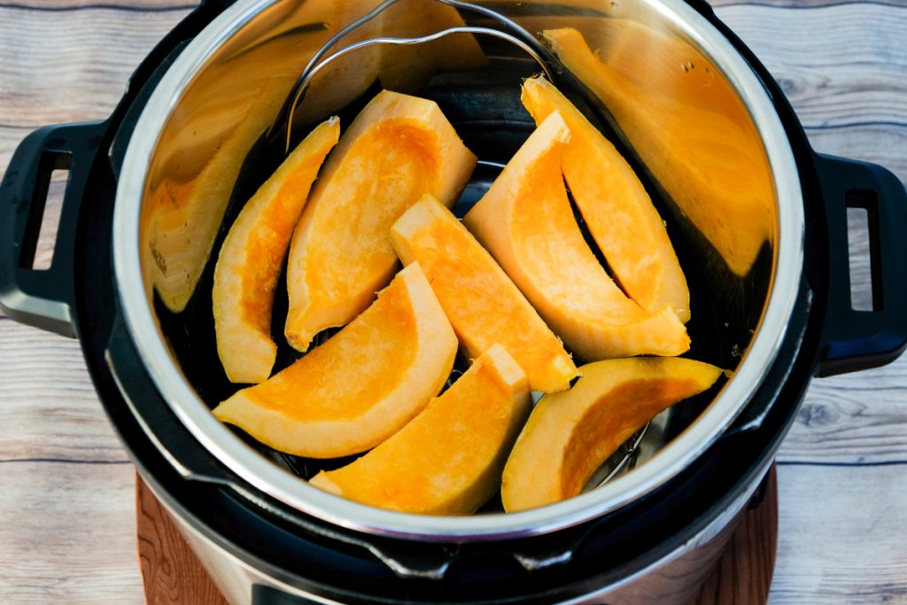Acorn squash cut in wedges in an Instant Pot before cooking. 