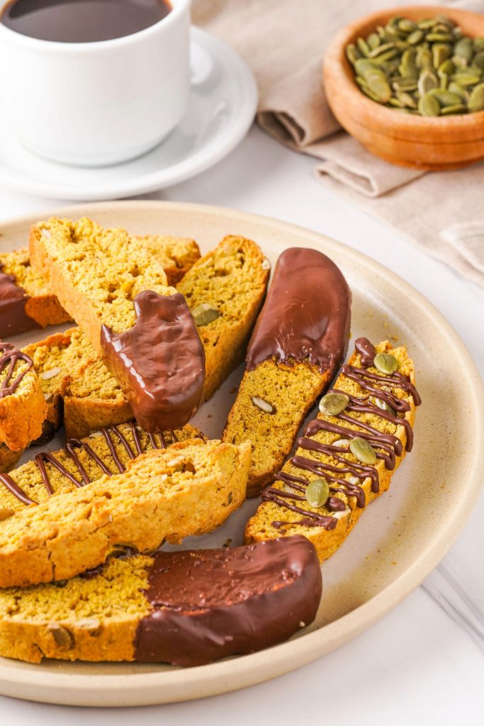 A plate full of pumpkin biscotti dipped in chocolate.