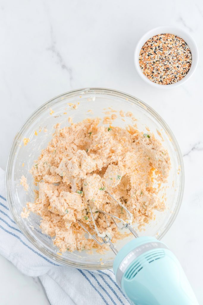 Blended cheese mix combined in a clear mixing bowl. 