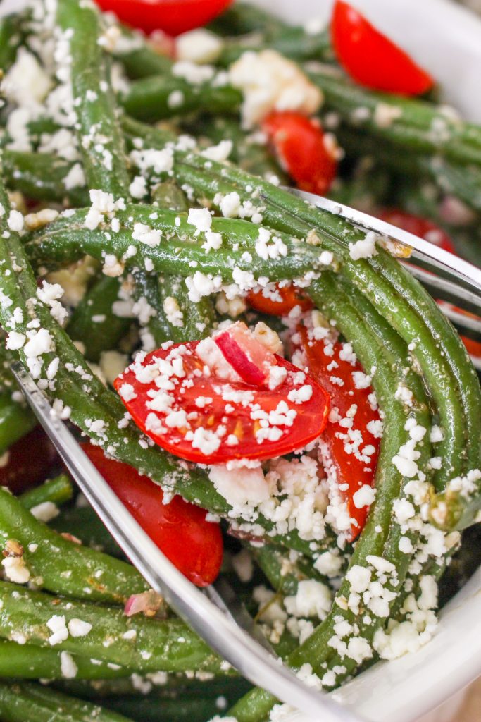 Green beans with tomatoes topped with crumbled feta.