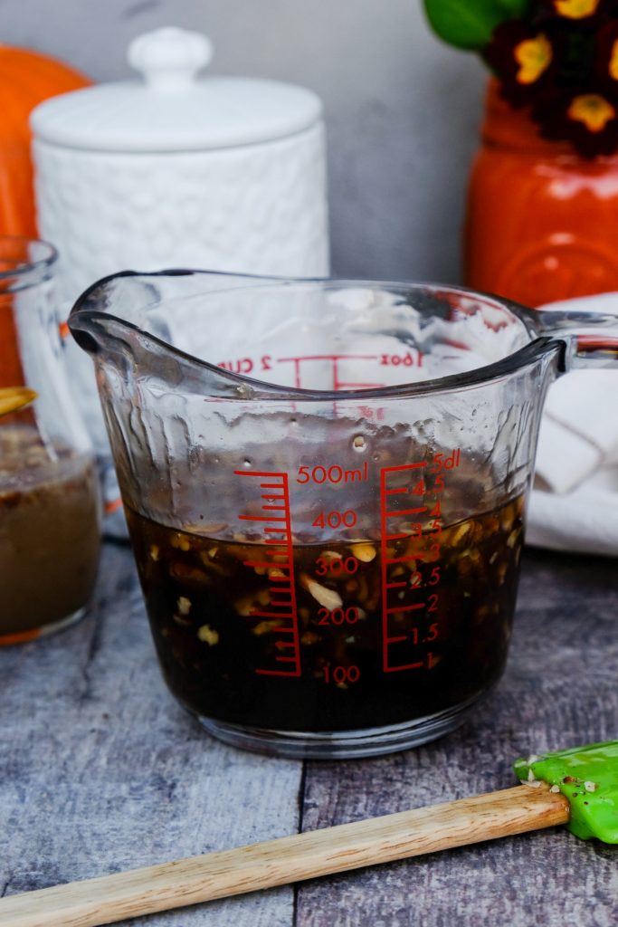 Homemade maple syrup in a glass measuring cup.