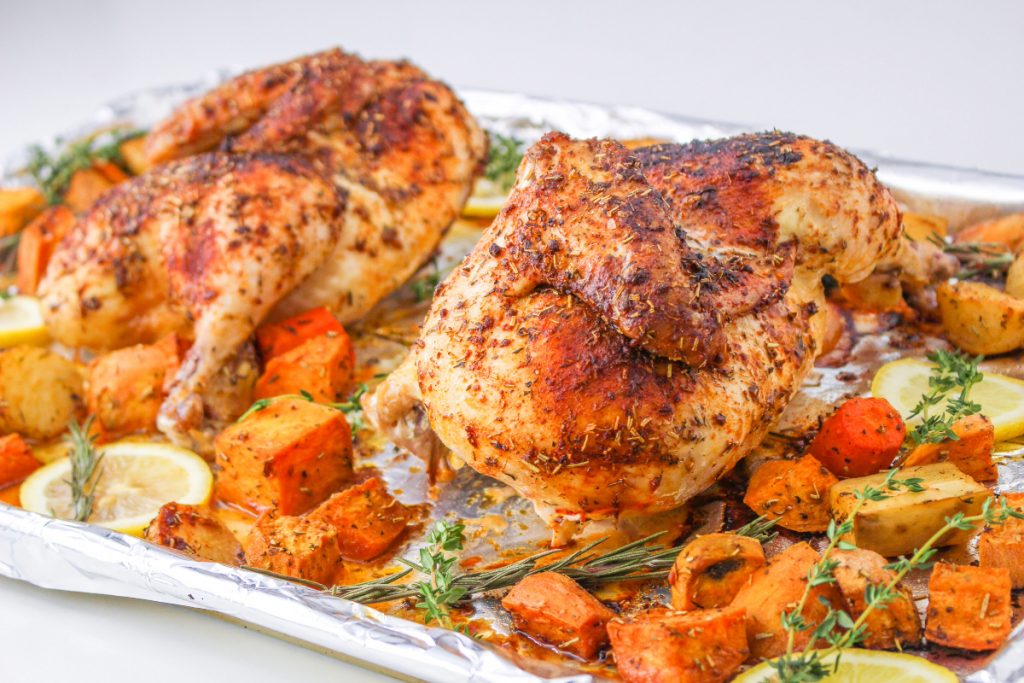 Cooked chicken with vegetables on a baking sheet. 