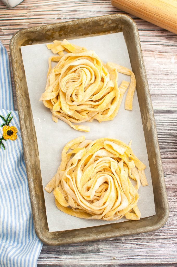 Top view of fresh pasta on a baking sheet lined with parchment paper.