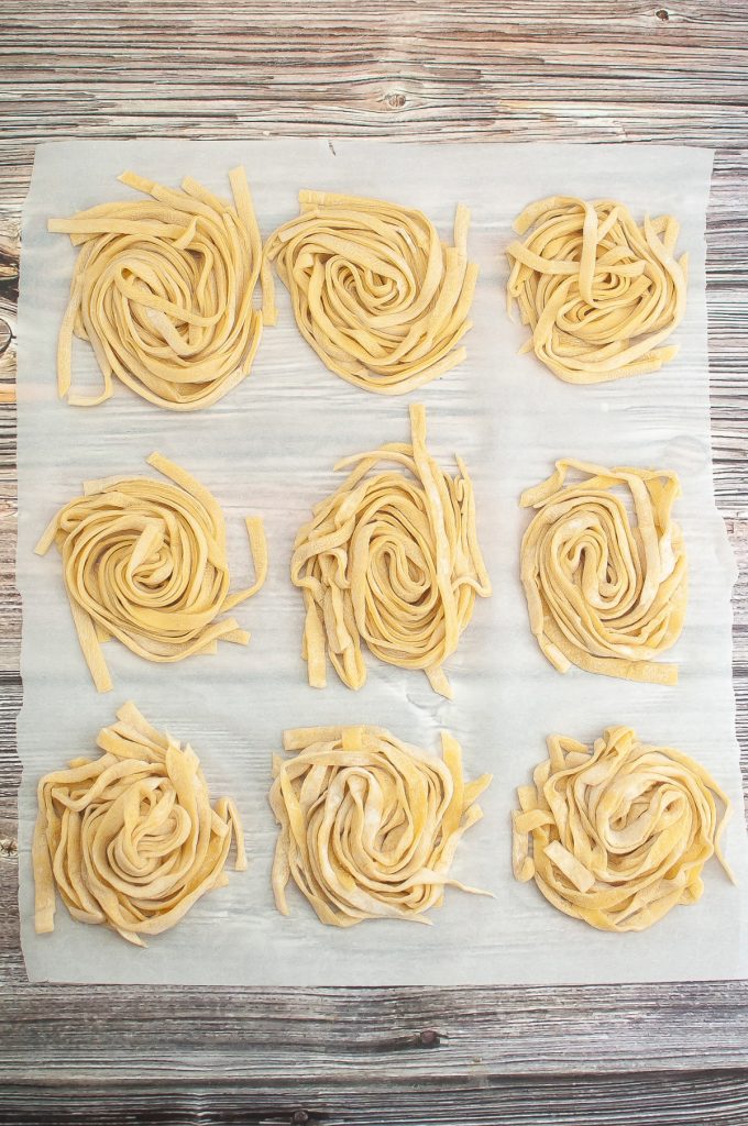 Pasta sliced and placed in nests on parchment paper. 