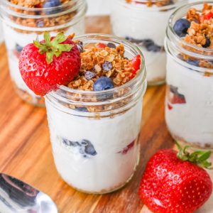 Mason jars filled with granola, fruit and yogurt.