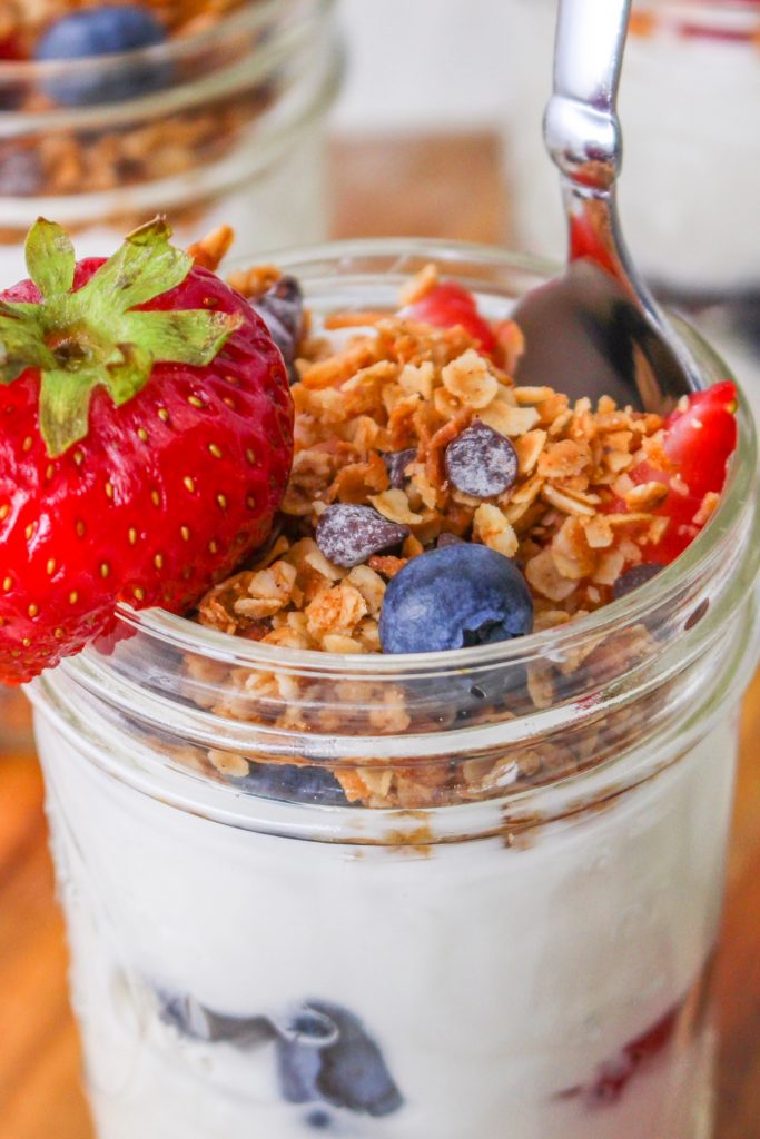 Mason jar filled with yogurt and topped with granola. 