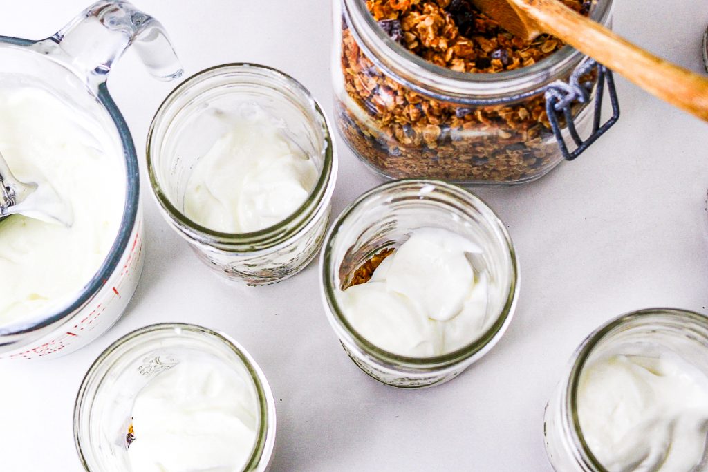 Top view of granola and yogurt on the bottom of a Mason jar. 