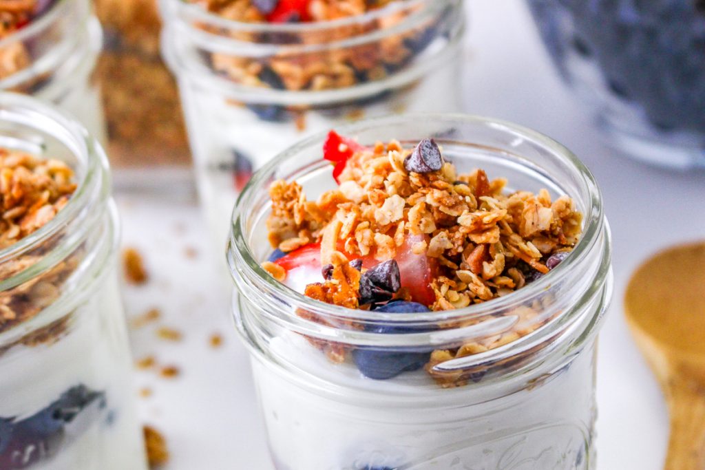 Yogurt parfaits in a Mason jar topped with homemade granola. 