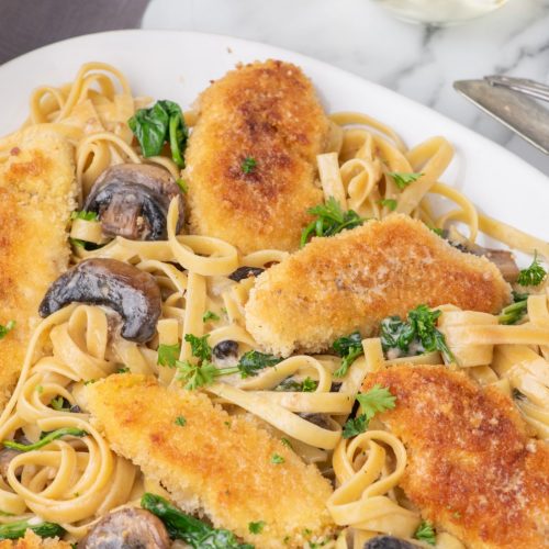 Copycat Olive Garden chicken marsala recipe on a platter with fettuccini.