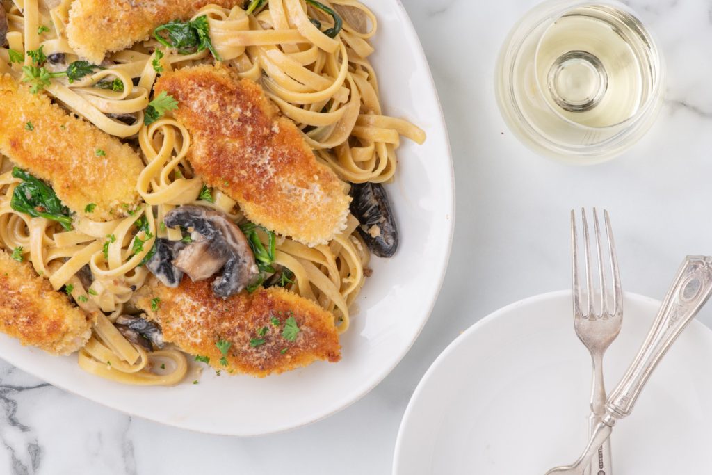 Homemade chicken Marsala recipe on a white platter. 