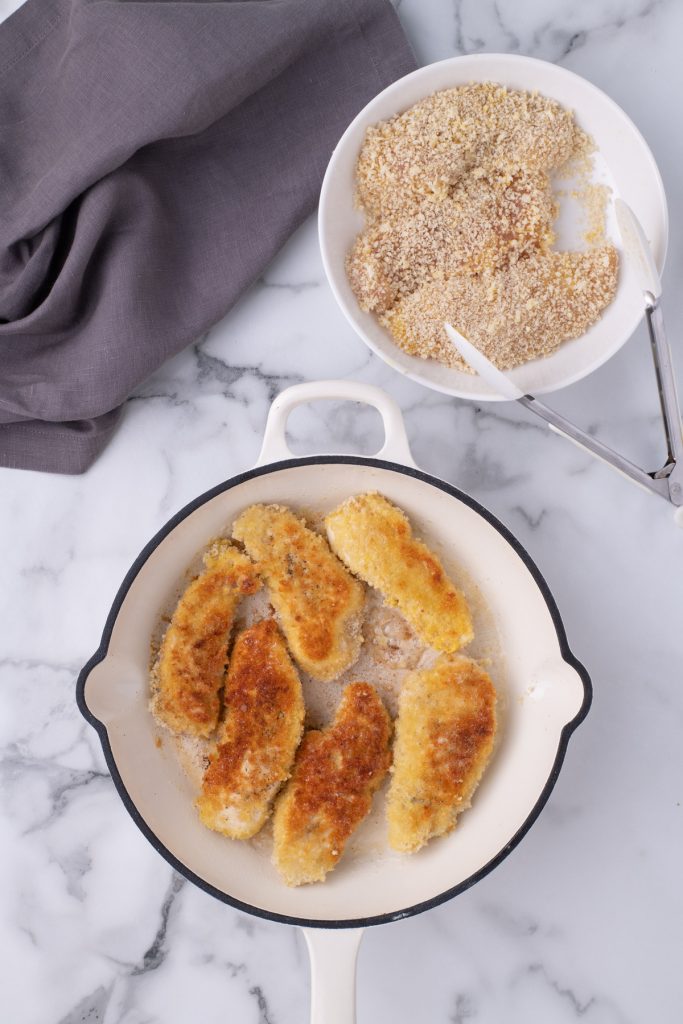 Chicken tenders cooked in a skillet. 