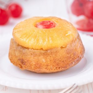 Pineapple upside down cupcakes topped with pineapple and a maraschino cherry.