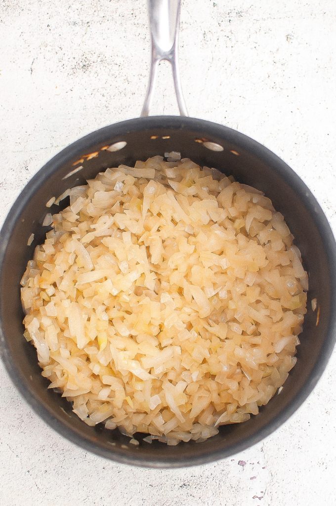 Cooked diced onion in a saucepan.