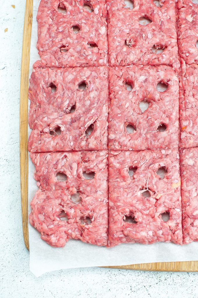 Ground beef cut into small squares with poked holes to steam when cooking.