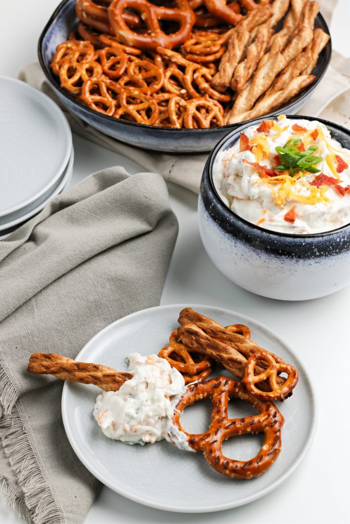 Top view of an appetizer plate with crack dip served with pretzels. 