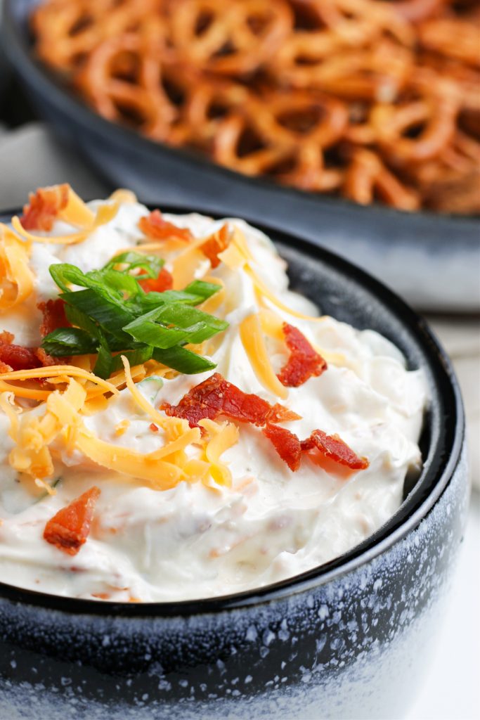 Dip with cheese bacon topped with green onions.