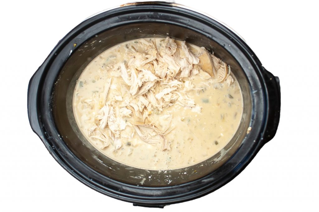 Shredded chicken in a slow cooker.