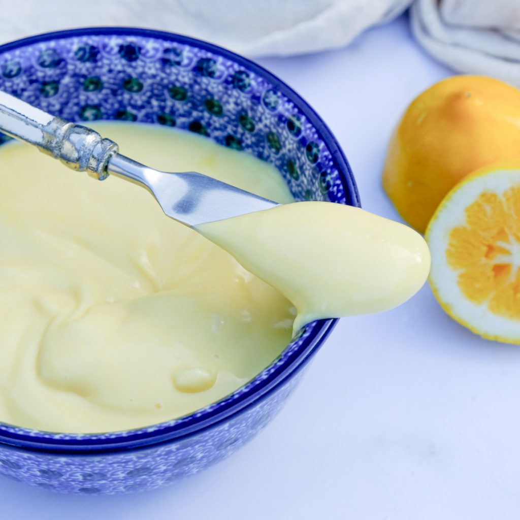 Homemade Whole 30 mayonnaise recipe in a small bowl with mayo on a small knife.