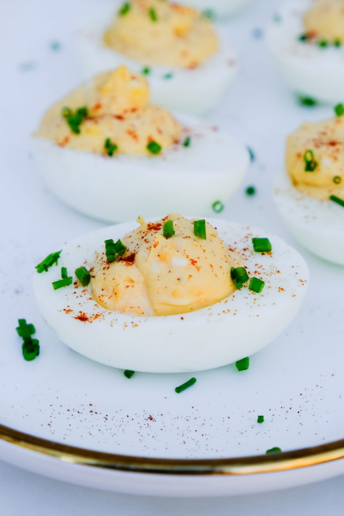Hard-boiled eggs cooked in an air fryer then made into deviled eggs on a white platter.