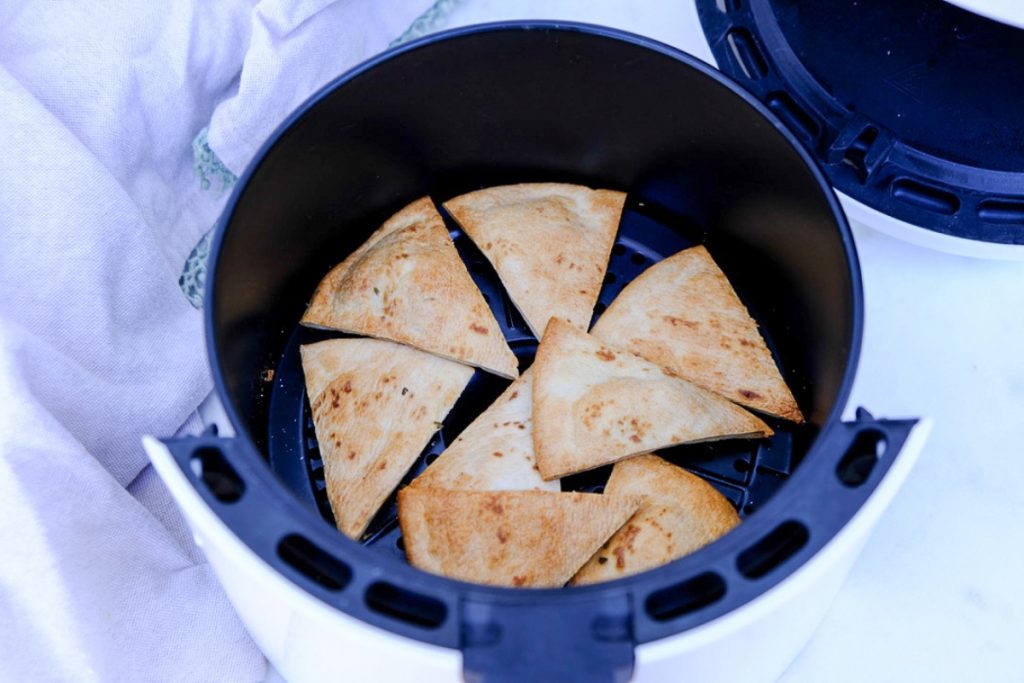 Air-fried pita chips in the air fryer basket. 