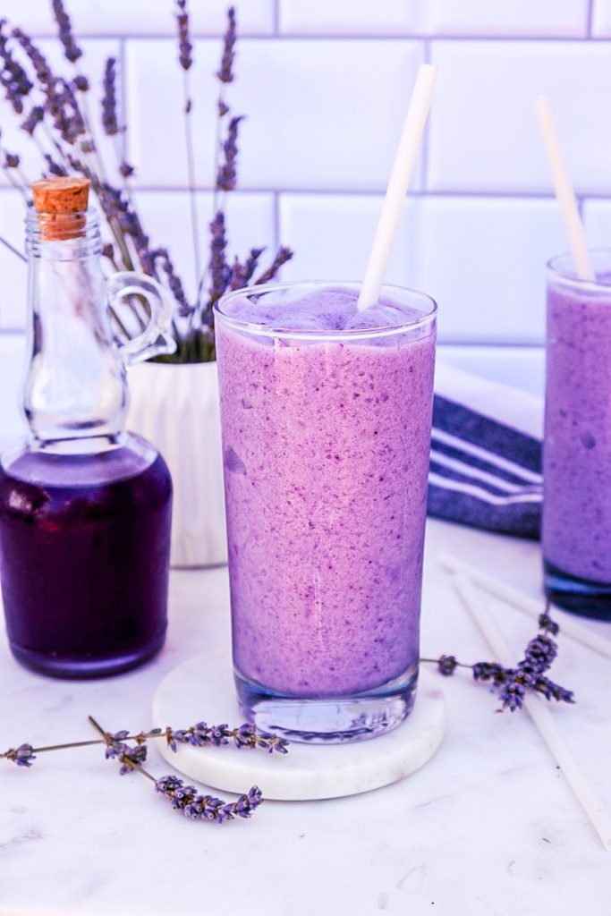 A clear glass filled with lavender frappuccino.