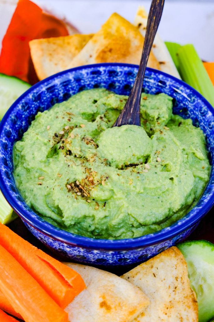 Homemade spinach hummus in a blue serving dish.