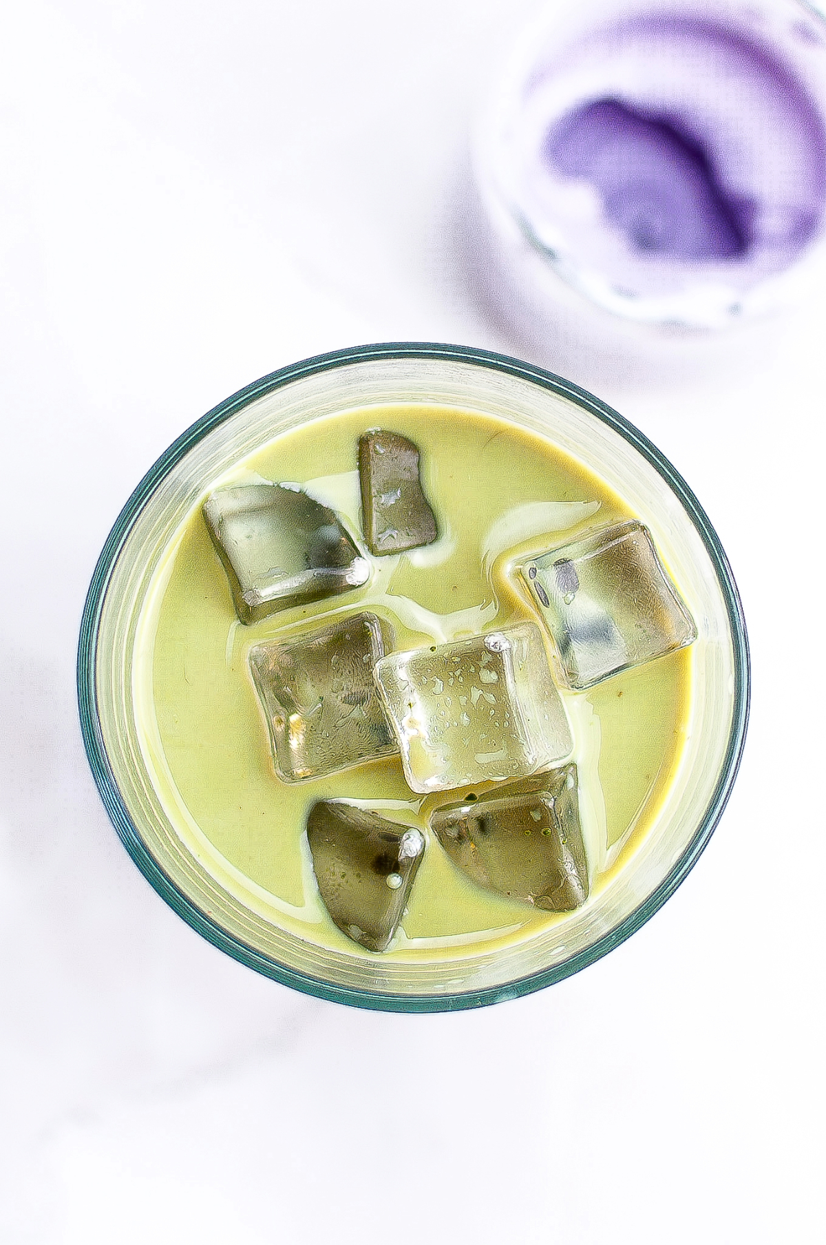 Matcha in a clear glass with ice before adding cold foam. 