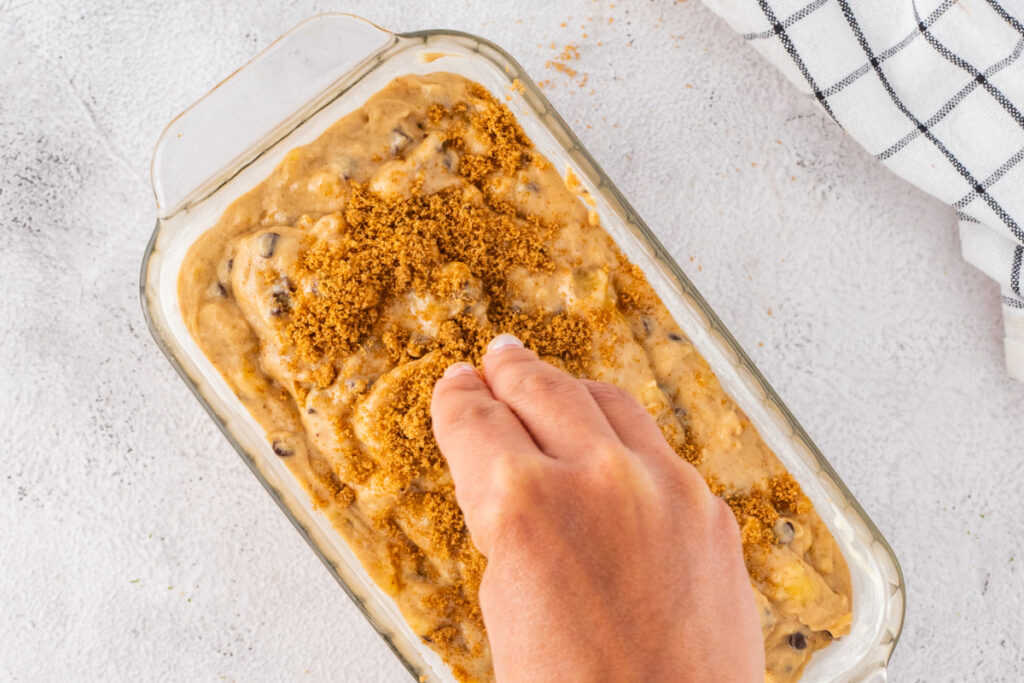 Adding streusel topping to bread before baking. 