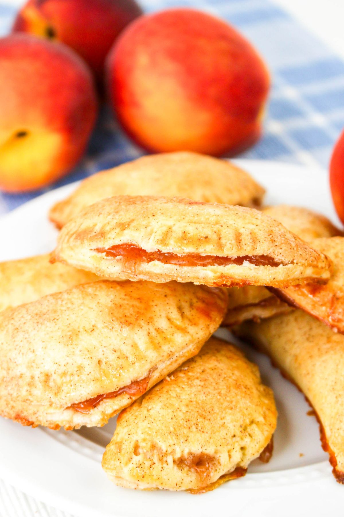 Peach hand pies stacked on a plate.