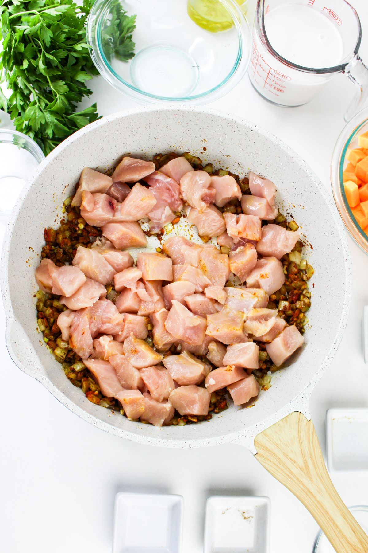 Chicken chunks being cooked in a large pot.