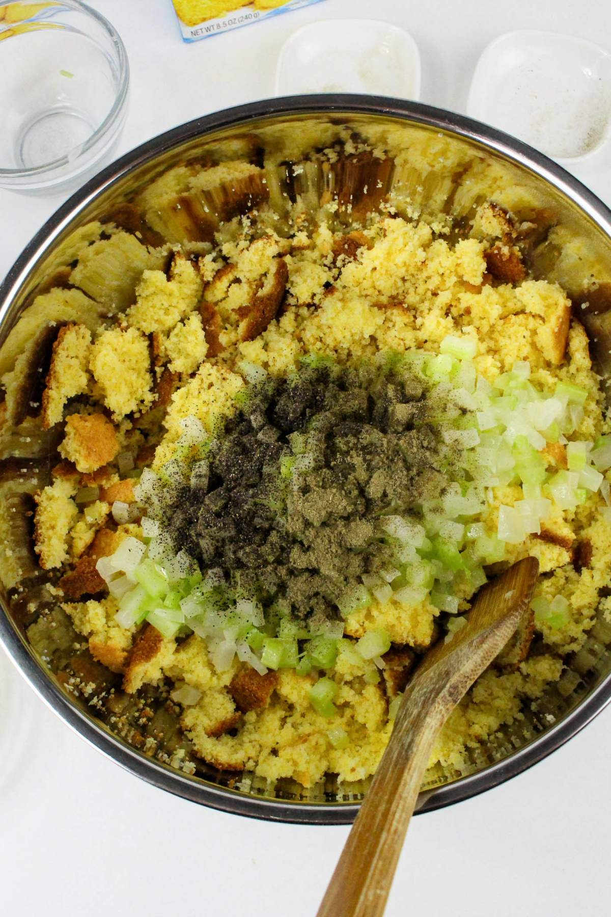 Cornbread, vegetables, and seasonings in a large bowl.