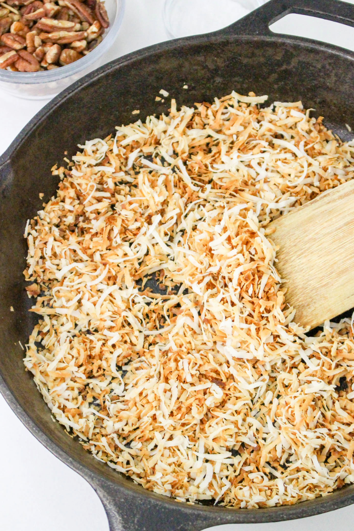 Coconut being toasted in a skillet.