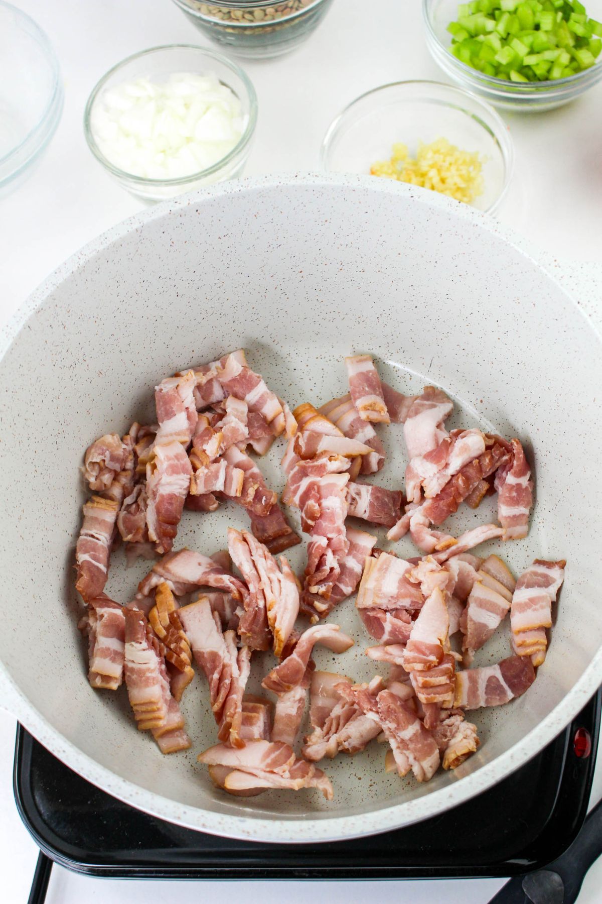 Bacon being cooked in a pot.