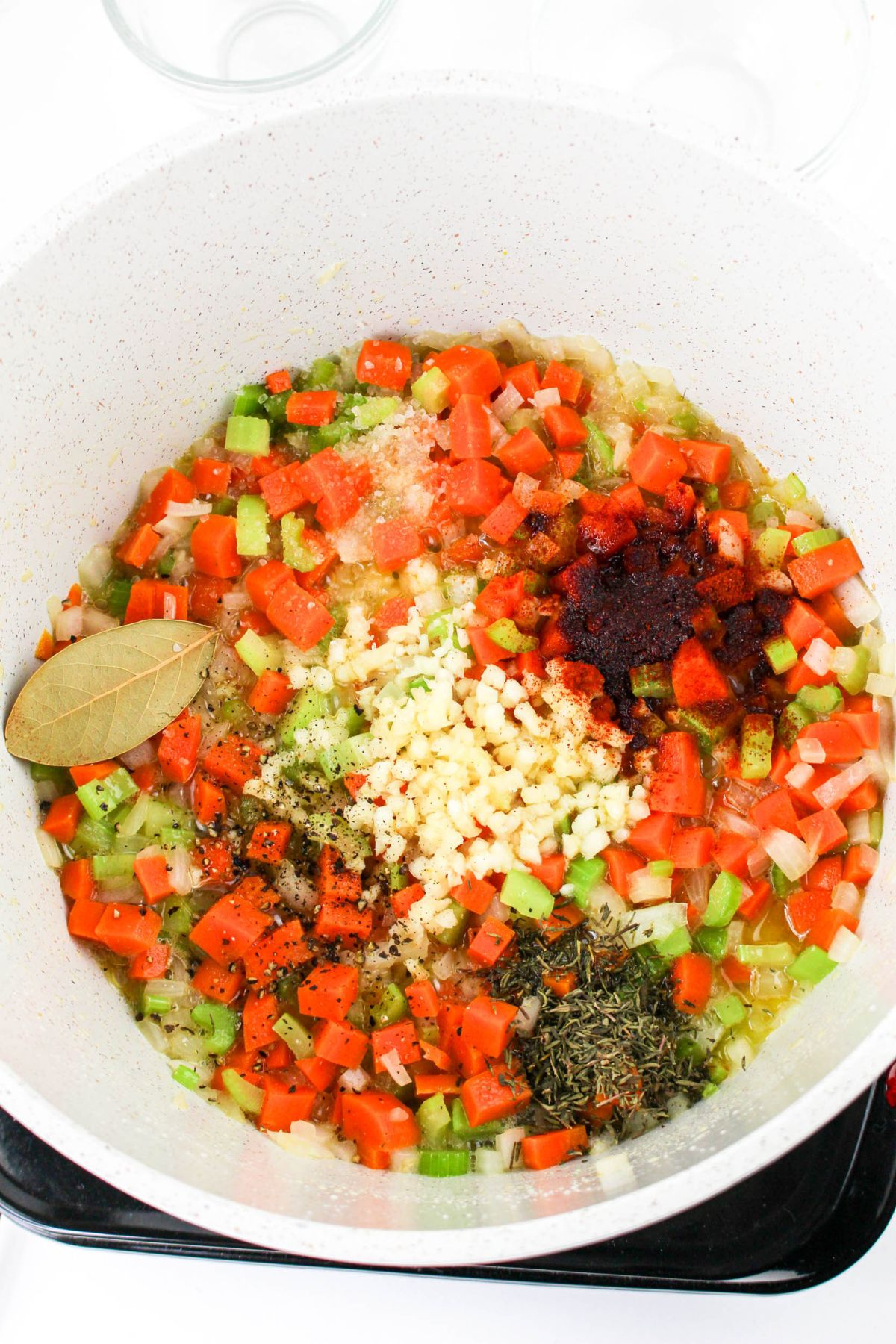 Carrots, celery, and garlic in a pot.