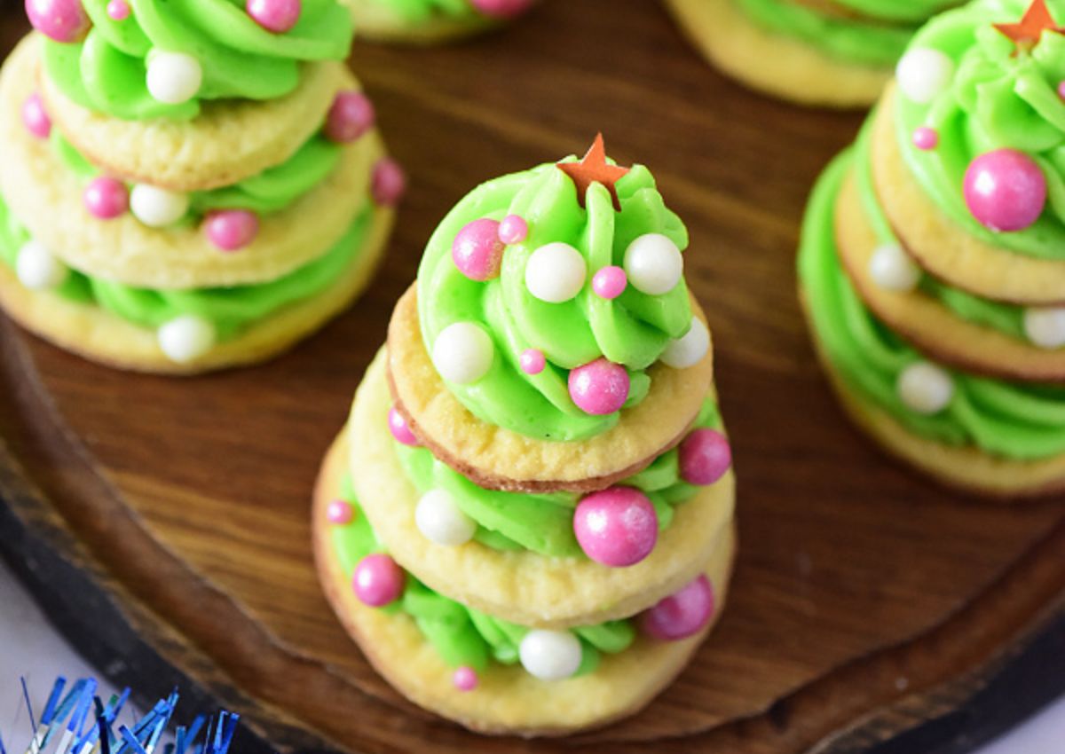 Christmas tree cookies on cutting board.