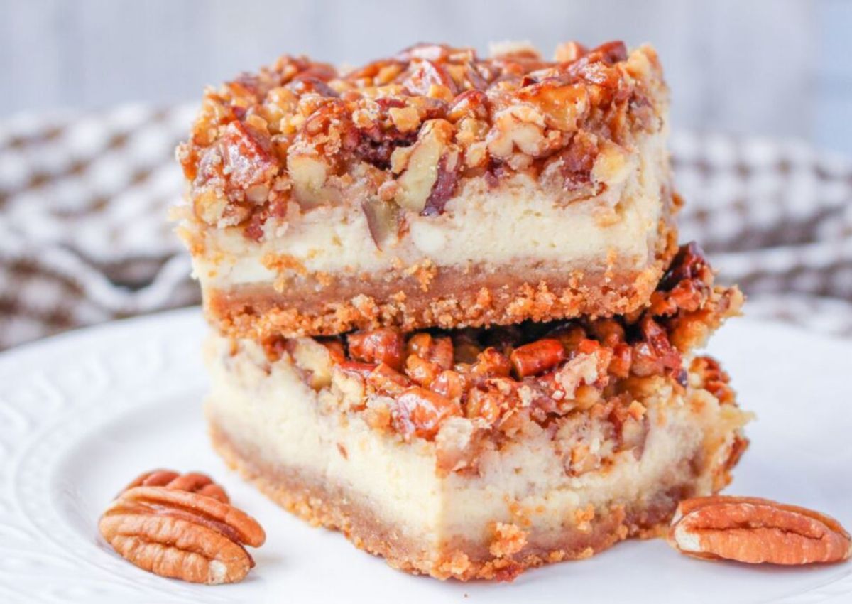 Pecan cheesecake bars stacked on top of each other.