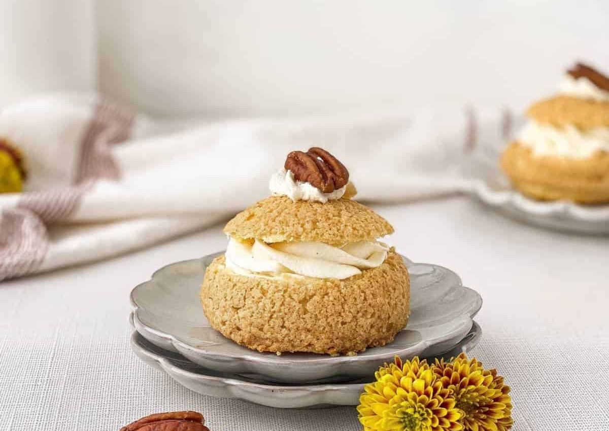 Pecan cream puff on a plate.