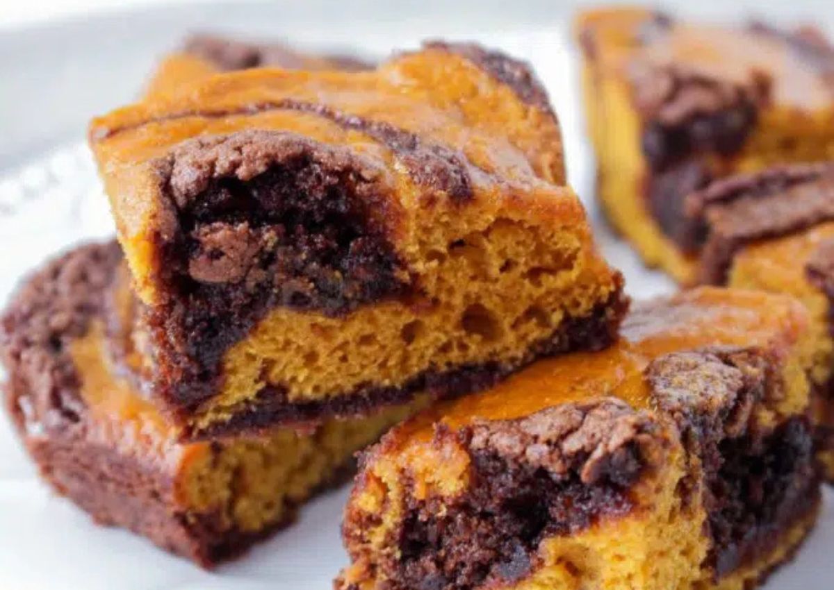 Pumpkin brownies stacked on a plate.