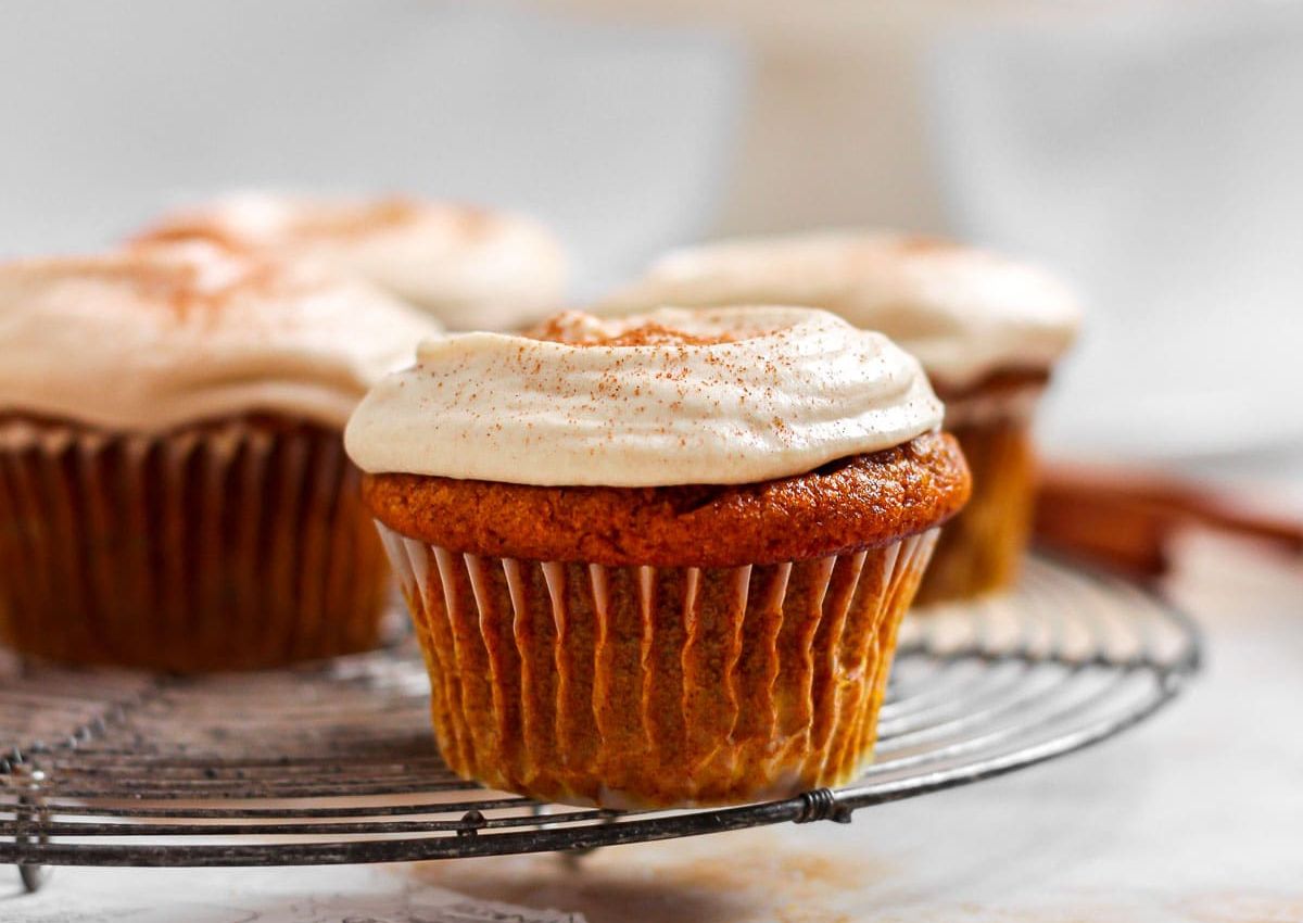 Pumpkin cupcakes on cooling rack.