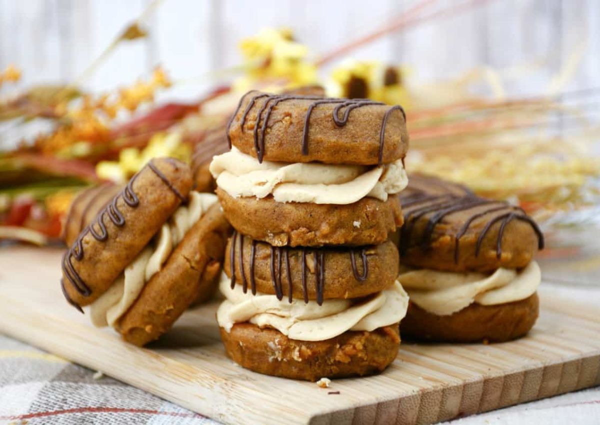 Pumpkin whoopie pies on a cutting board.