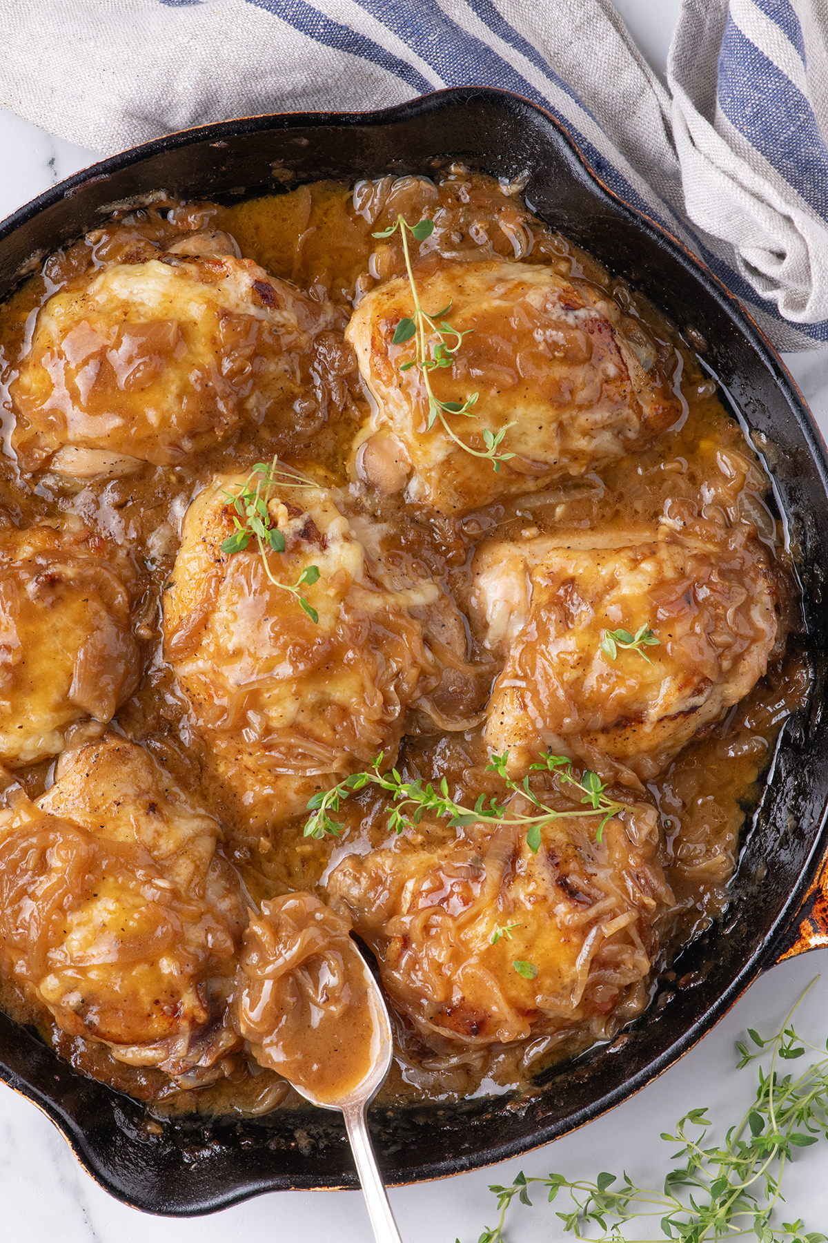 Chicken in a iron cast skillet with sautรฉed onions.