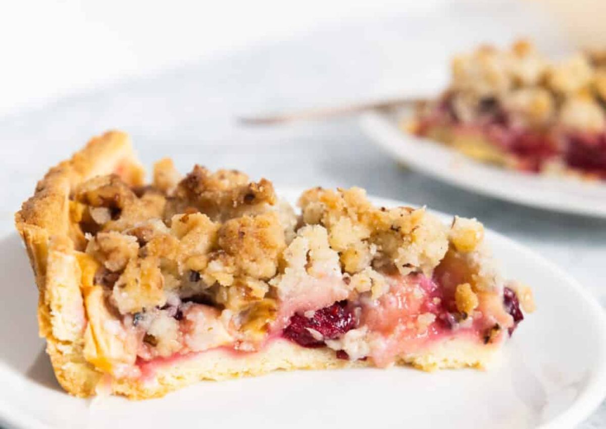 Slice of cranberry apple pie on plate.