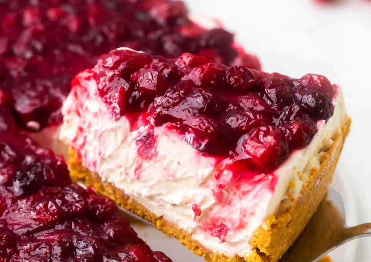Slice of cranberry cheesecake on a spatula.