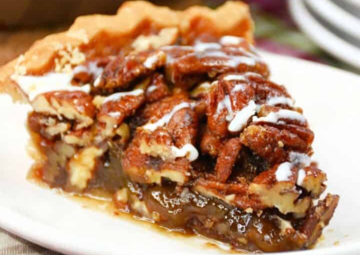 Slice of whiskey pecan pie on a plate.