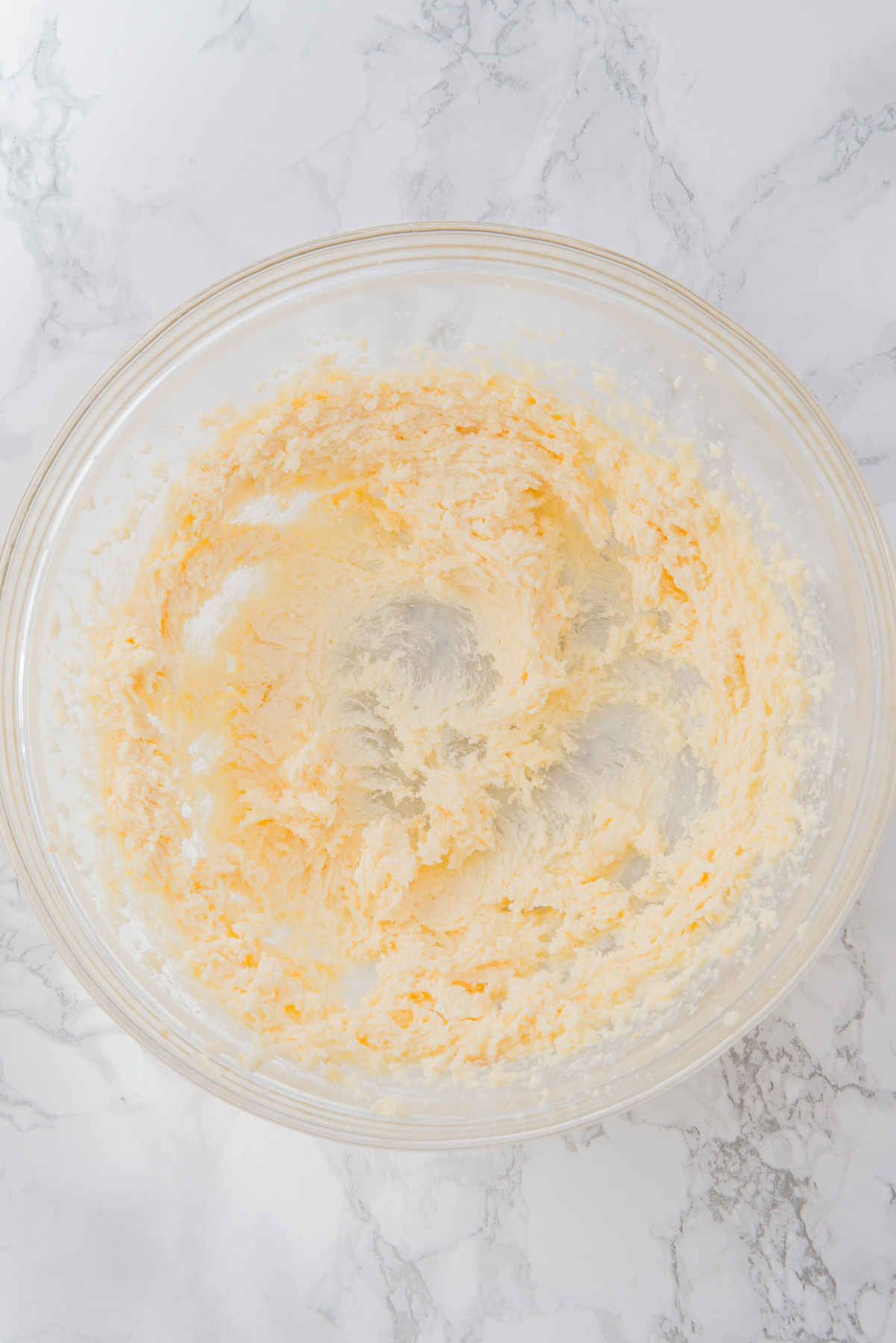 Creamed butter, sugar and vanilla in a clear mixing bowl.